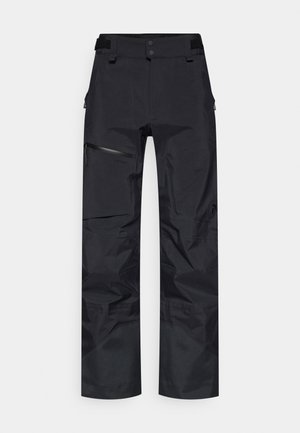 Sorte vandtætte bukser med løs pasform, elastisk talje, lynlåslommer i siderne og tekstureret stof for holdbarhed.