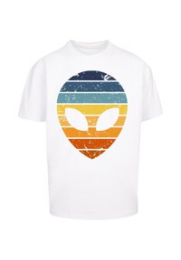 White cotton t-shirt featuring a distressed alien graphic in horizontal stripes of blue, yellow, and orange. Classic crew neck design.