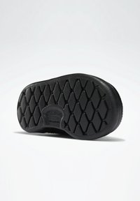 Černá gumová podrážka s texturovaným diamantovým vzorem pro lepší přilnavost, s kulatým podpatkem a hladkým okrajem. Čistý a minimalistický design.