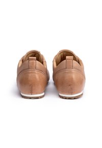 Bruine leren schoenen met een gladde afwerking, ronde vorm, witte zool en minimale stiksels bij de hak.