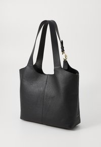Black leather tote bag with textured exterior, open top, and dual handles. Features a gold-tone hardware accent on the side.