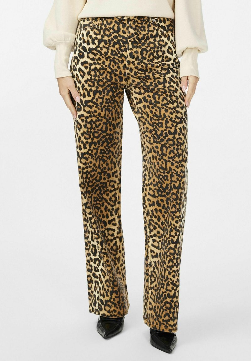 Pantalones de pierna ancha con estampado de leopardo en tela marrón y negra, que presentan una cintura alta y bolsillos laterales, combinados con tacones negros puntiagudos.