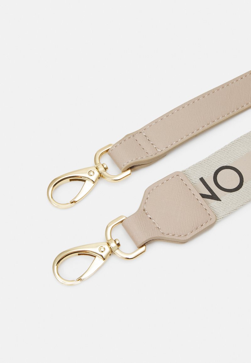 Cinghia in tessuto beige con hardware dorato e due attacchi a clip. Un lato presenta una fascia chiara con testo nero. Texture liscia.