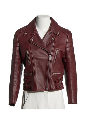 Chaqueta de cuero burdeos para motorista con cremallera asimétrica, detalles acolchados en los hombros, bolsillos con cremallera y hebillas laterales ajustables en un maniquí blanco.