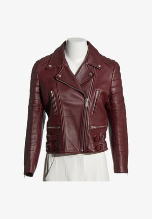 Chaqueta de cuero burdeos para motorista con cremallera asimétrica, detalles acolchados en los hombros, bolsillos con cremallera y hebillas laterales ajustables en un maniquí blanco.