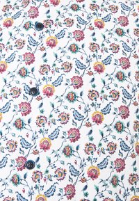 Tissu floral à fond blanc, présentant des roses colorées en rose, rouge et jaune, soulignées par des feuilles vertes et des vignes bleues ; comprend des boutons foncés.