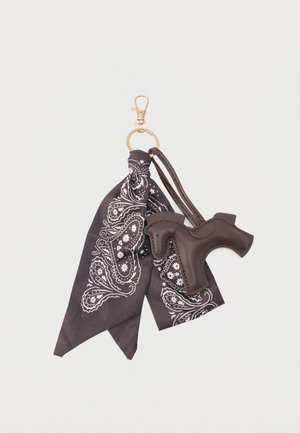 Gouden sleutelhanger met een zwarte paisley bandana en een donkerbruin leren paardenvormige hanger eraan bevestigd.