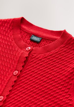 Cardigan rosso a maglia con motivo strutturato, caratterizzato da una patta con bottoni smerlata e due bottoni rosa. Etichetta visibile all'interno.