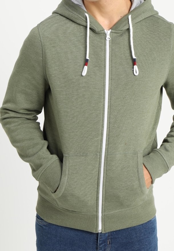 Olivgrüner Zip-Hoodie mit einer grauen gefütterten Kapuze, ausgestattet mit weißen Kordeln, Fronttaschen und gerippten Bündchen sowie Saum.