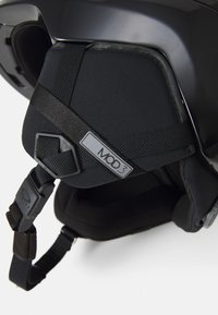 Zwarte helm met gevoerde neksteun, voorzien van verstelbare riemen, MOD3-label en textuuraccenten voor comfort.