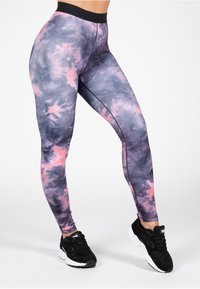 Leggings gemaakt van rekbare stof, met een paars en roze tie-dye patroon, voorzien van een hoge tailleband en platte naden voor comfort.