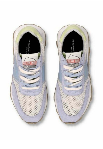 Lys blå og beige sneakers med mesh- og ruskindsteksturer, hvide snørebånd og et logo-label på tungen. Gummisålen giver godt greb.