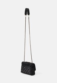 Bolso de mano acolchado negro con tapa, que cuenta con una correa de cadena y un asa negra lisa. Superficie texturizada con un patrón de diamante y herrajes dorados.