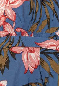 Tessuto floreale con grandi fiori rosa e marroni su uno sfondo blu. Il motivo è vivace con una trama texturizzata.