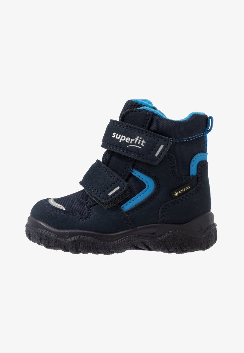 Botas de senderismo de color azul marino oscuro con detalles en azul, dos correas de Velcro, suela de goma texturizada, impermeables con GORE-TEX y cuello acolchado para mayor comodidad.