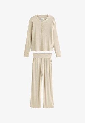 Ensemble de loungewear beige côtelé composé d'un haut à manches longues avec patte de boutonnage et d'un pantalon large à taille élastique. Texture douce, design décontracté.