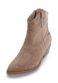 Bottine en suede beige avec un bout pointu, fermeture éclair et coutures décoratives à l'avant. Talon bloc modéré pour le soutien.