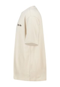 Beige puuvillane T-särk lühikeste varrukatega, ümmarguse kaelusega ja vasakul rinnal klambri tekstiga. Sile tekstuur, mugav lõike.