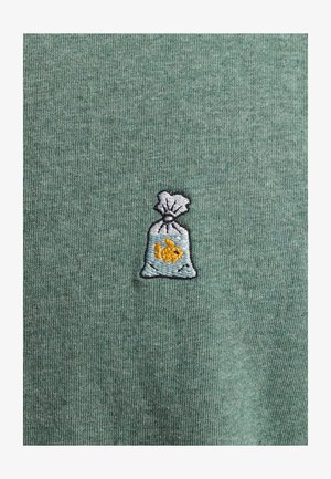 Groene katoenen stof met een geborduurd grijze tas met een vis erin. Gelaagde achtergrond met subtiele ribbels.