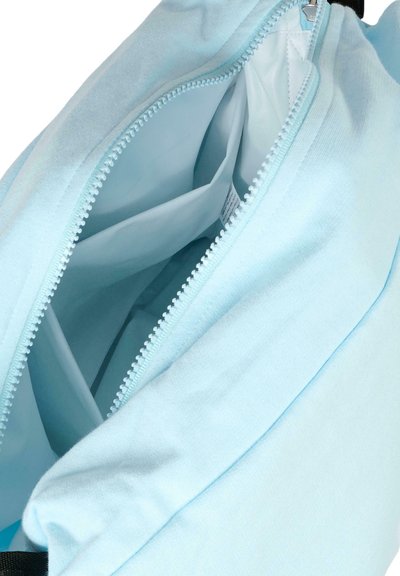 Zaino in tessuto azzurro chiaro con apertura con zip, dotato di scomparti interni e texture liscia. I dettagli della zip sono visibili.