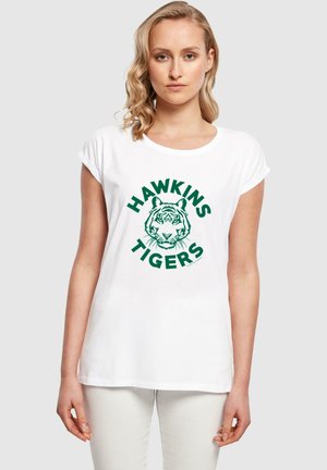 Hvid bomulds T-shirt med opuldet ærmer, med en grøn grafisk print af en tiger og teksten "HAWKINS TIGERS" i fed skrift.