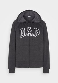 Sweat à capuche zippé gris foncé avec doublure en polaire, présentant un grand logo "GAP" blanc sur le devant, deux poches avant et des poignets côtelés.