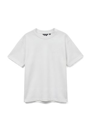 T-shirt bianca semplice a maniche corte con scollo tondo, con un logo in rilievo discreto sul petto e un'etichetta del marchio nera all'interno del colletto.