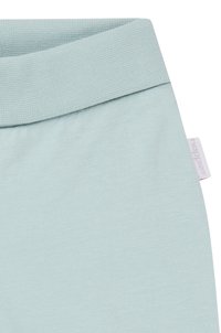 Helle blaue Stoff mit glatter Textur, mit einem breiten gerippten Bund und einem kleinen Markenetikett an der Seite.