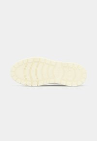 Semelle de chaussure en caoutchouc de couleur crème avec un motif de bande de roulement comportant des rainures courbes et droites, un logo "Gabor" et une indication de taille "4½".