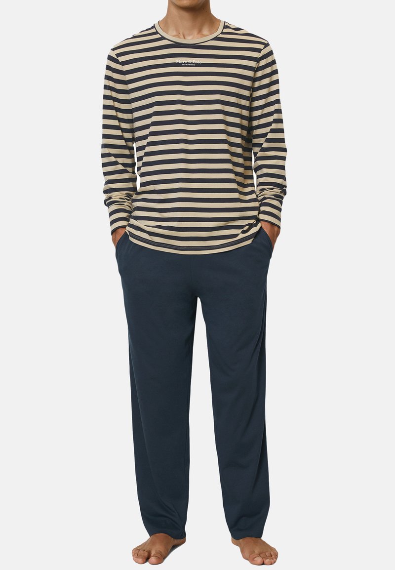 Chemise à manches longues rayée beige et marine avec un col ras du cou, associée à un pantalon bleu foncé, tous deux en tissu doux. Coupe décontractée.
