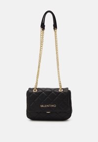 Schwarze gesteppte Lederhandtasche mit einem goldenen Kettenriemen. Verfügt über einen Magnetverschluss und ein geprägtes Logo auf der Vorderseite. Kompakte rechteckige Form.