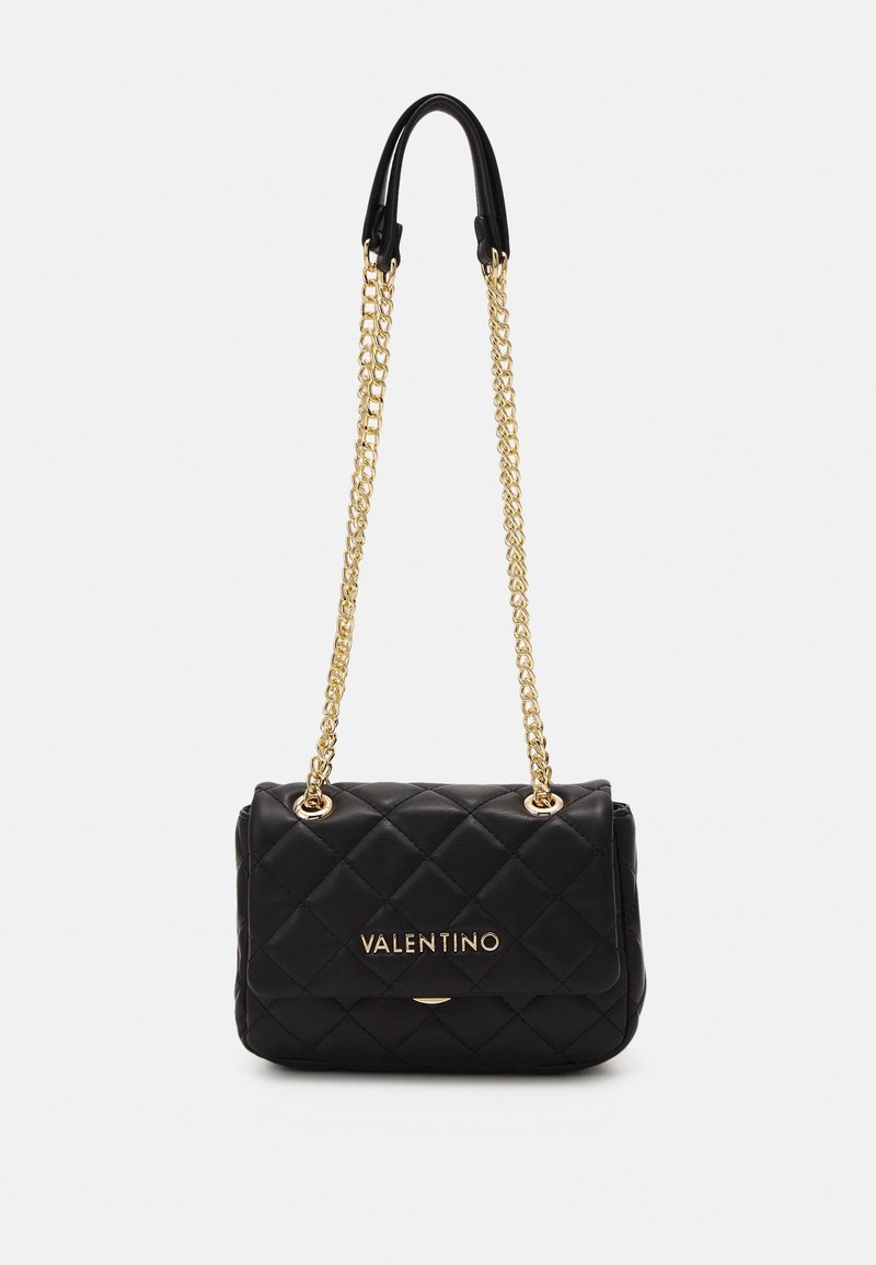 Schwarze gesteppte Lederhandtasche mit einem goldenen Kettenriemen. Verfügt über einen Magnetverschluss und ein geprägtes Logo auf der Vorderseite. Kompakte rechteckige Form.