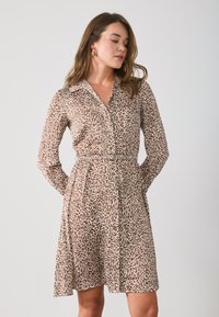Robe en imprimé léopard marron et beige avec des manches longues, un col, un devant boutonné et une taille ceinturée. Tissu léger avec une jupe fluide.