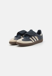 Blaue und beige Leder-Sneaker mit Gummisohlen, die drei gestreifte Akzente, eine gepolsterte Zunge und runde Schnürsenkel aufweisen.