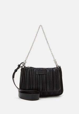 Sac à bandoulière en cuir noir plissé avec une chaîne argentée et une sangle en cuir réglable, posé sur un fond blanc.