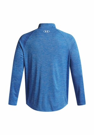 Camisa de manga larga azul con un cuello alto, textura en forma de onda y logo en la parte trasera. Fabricada con un tejido que absorbe la humedad.