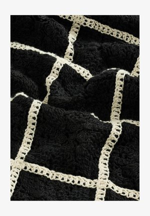 Black textured blanket featuring a woven cream grid pattern, with raised floral designs and a soft, plush finish.