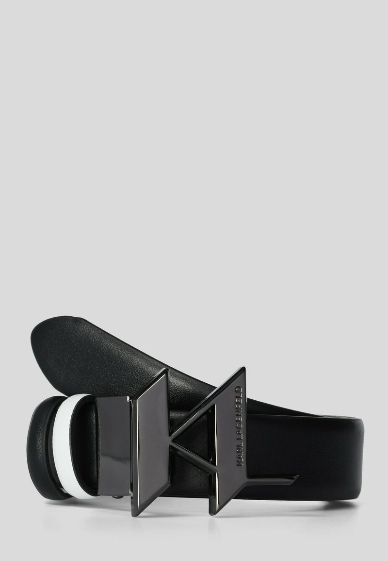 Ceinture en cuir noir avec boucle géométrique noire brillante sur laquelle est gravé "Karl Lagerfeld" sur le côté, enroulée sur un fond gris.