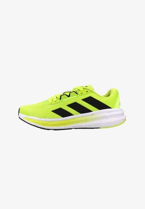 Zapatilla de running de color amarillo neón brillante con rayas negras, suela blanca y neón, y diseño con cordones vista de lado.