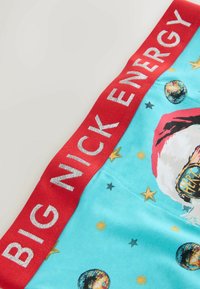 Gaiši zilas bokseršorti ar sarkanu elastīgu vidukļa joslu, uz kuras sudrabotā krāsā redzams uzraksts "BIG NICK ENERGY". Dekorēti ar zvaigznēm un disko bumbām.