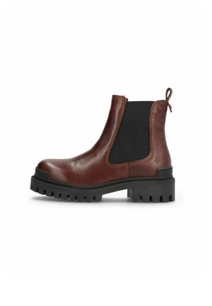 Bottine en cuir marron avec des panneaux élastiques noirs sur les côtés et une semelle noire épaisse à crampons, vue de l'extérieur.