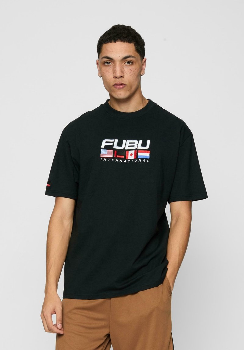 Sort bomulds t-shirt med et hvidt og farvet FUBU-logo med internationale flag. Designet har korte ærmer og en afslappet pasform.