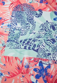 Tissu à motifs présentant des léopards illustrés en bleu et violet, entrelacés avec un feuillage corail et teal sur un fond clair.