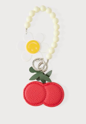 Porte-clés à perles avec des perles jaunes, un pendentif marguerite blanc et jaune, et un pendentif cerise en cuir rouge avec des feuilles vertes.