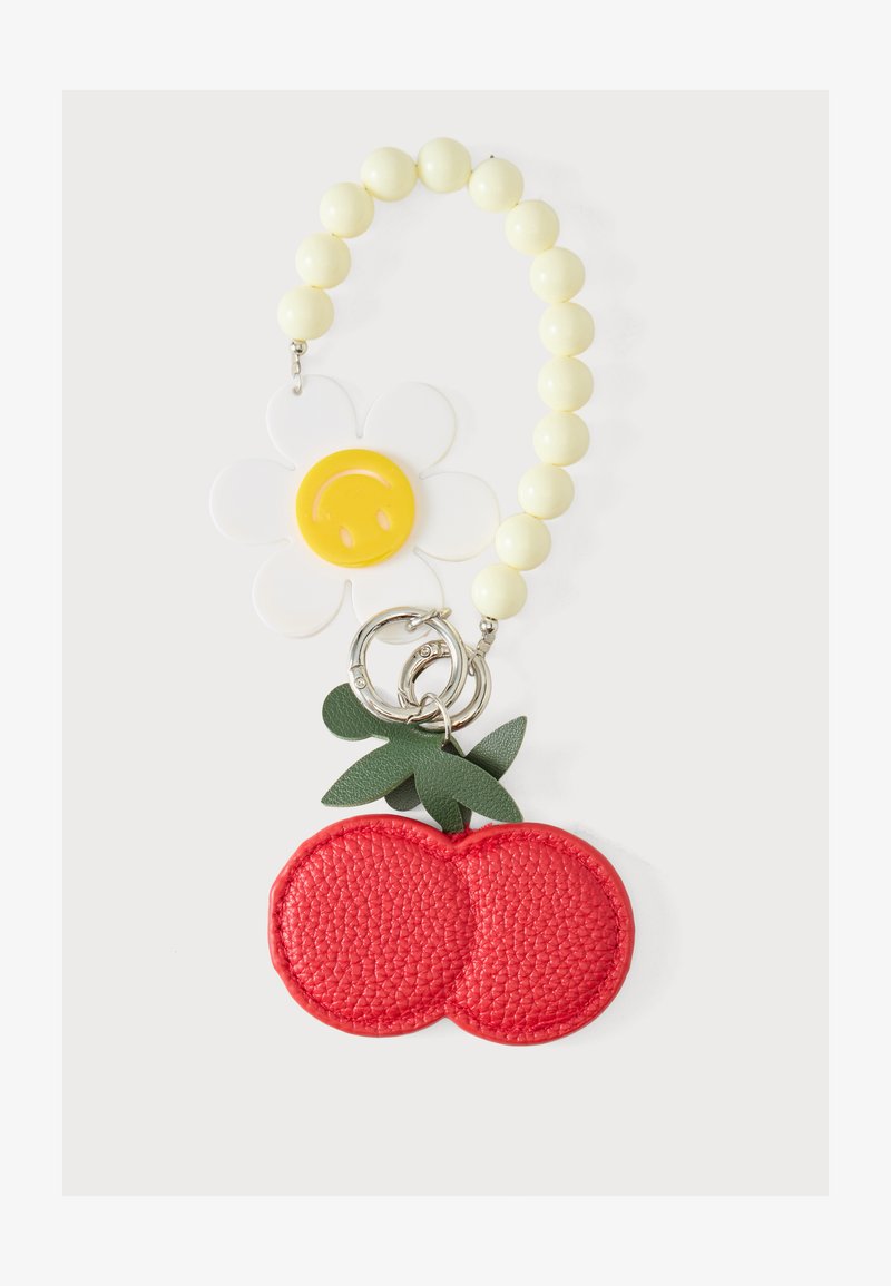 Porte-clés à perles avec des perles jaunes, un pendentif marguerite blanc et jaune, et un pendentif cerise en cuir rouge avec des feuilles vertes.