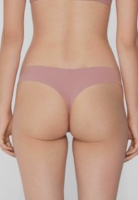 Roze naadloze slip met een gladde textuur en minimalistisch ontwerp, voorzien van een brede elastische tailleband en zonder zichtbare naden.