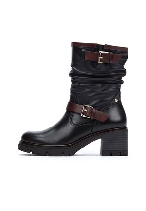 Bottine en cuir noir avec un design froncé, une sangle en cuir marron et un détail de boucle, un talon épais et une semelle texturée pour une meilleure adhérence.