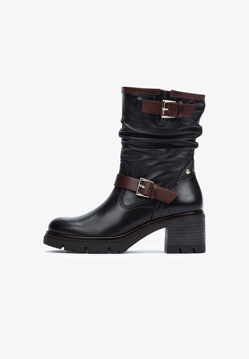 Bottine en cuir noir avec un design froncé, une sangle en cuir marron et un détail de boucle, un talon épais et une semelle texturée pour une meilleure adhérence.