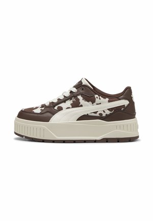 Basket à plateforme basse avec motif tacheté marron et blanc, bande Puma blanche, lacets blancs et semelle épaisse beige.