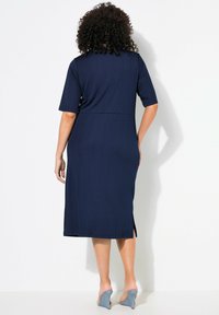 Granatowa sukienka midi z krótkimi rękawami, prążkowaną teksturą, bocznymi rozcięciami i dopasowaną talią. Zaprojektowana z myślą o komforcie i swobodzie ruchów.
